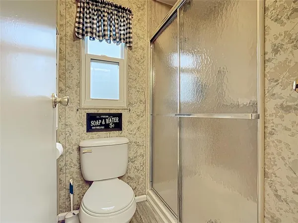 a bathroom with a toilet and a shower