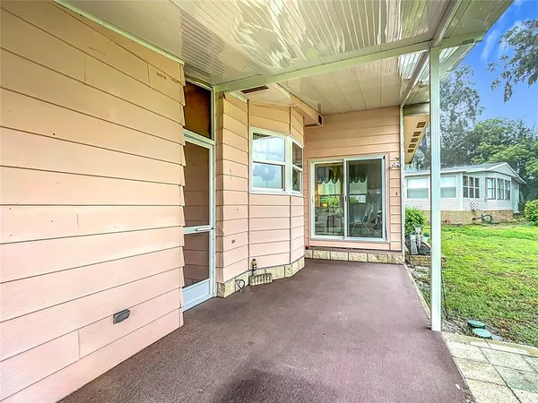 a view of a house with a small yard and wooden floor and fence