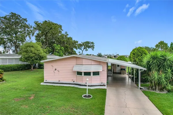 a view of a house with backyard and sitting area