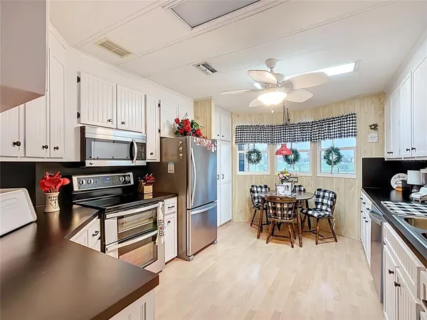 a kitchen with stainless steel appliances kitchen island granite countertop a refrigerator and microwave