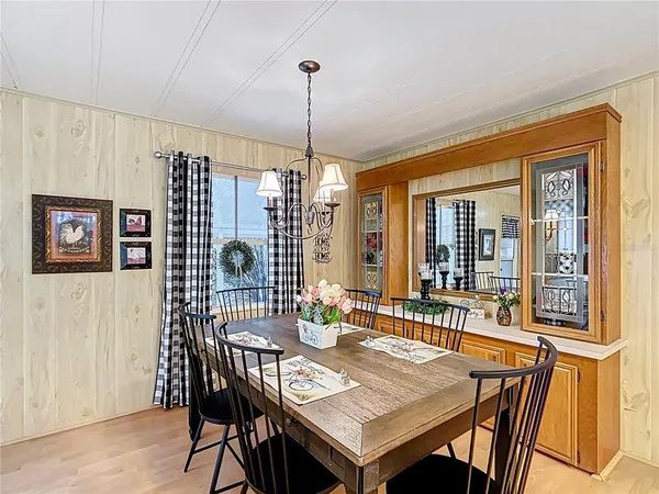 a dining room with furniture a chandelier and window