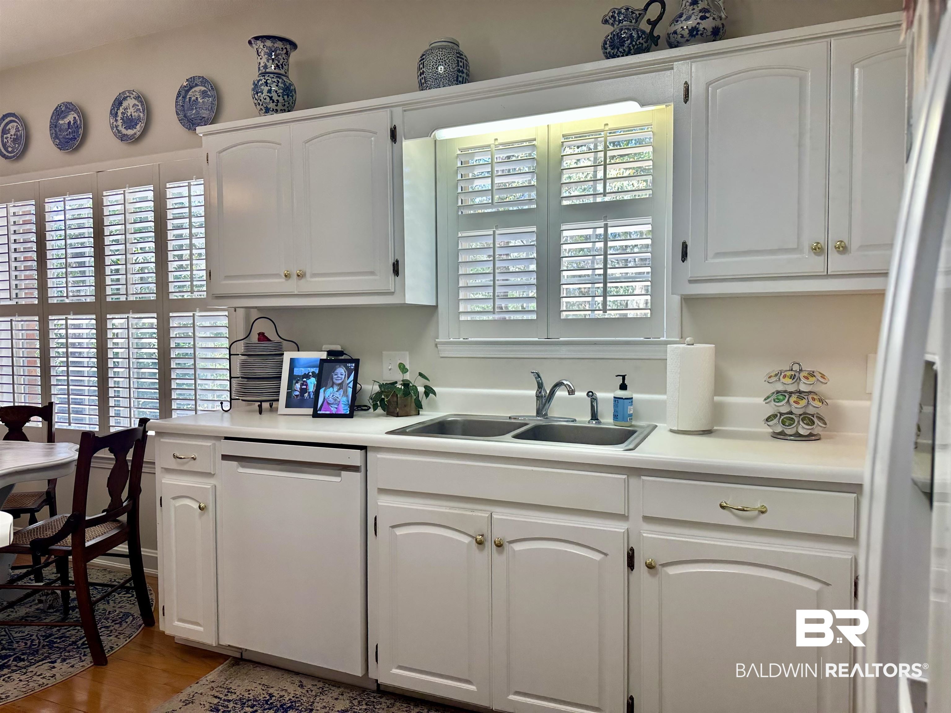 148 Brooks Boulevard Brewton, AL 36426 - Photo 12 of 45 Kitchen with a sink, white appliances, light countertops, and white cabinetry