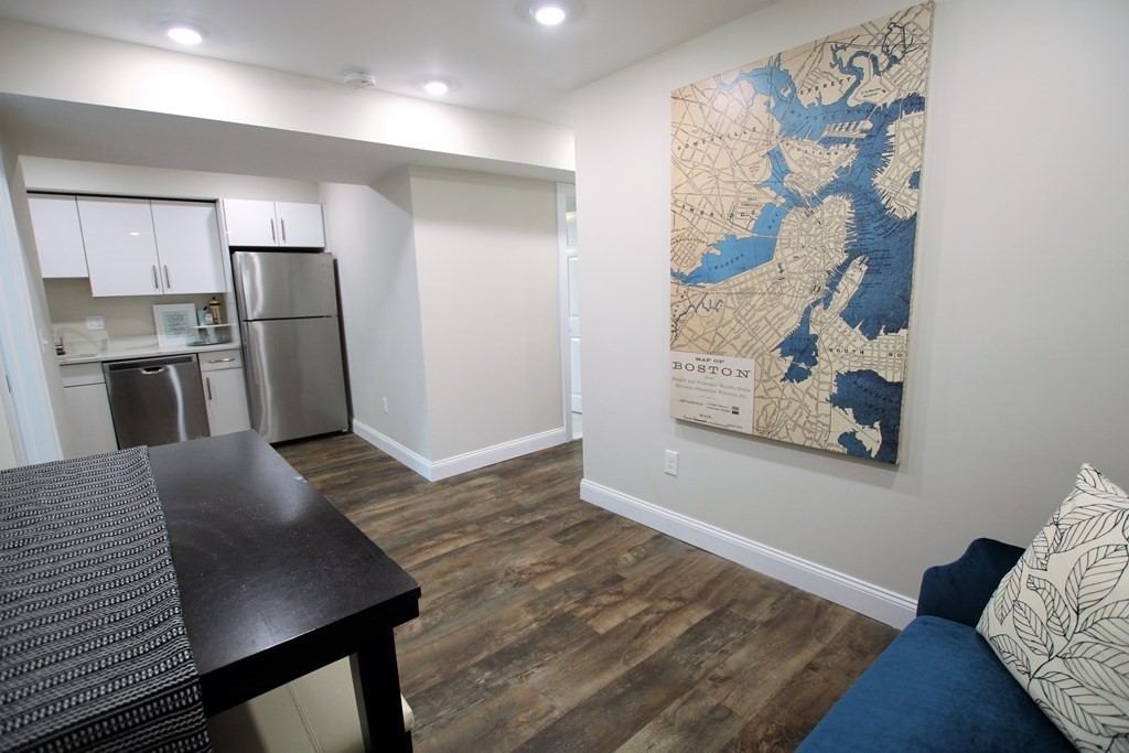 a view of a kitchen with furniture and wooden floor