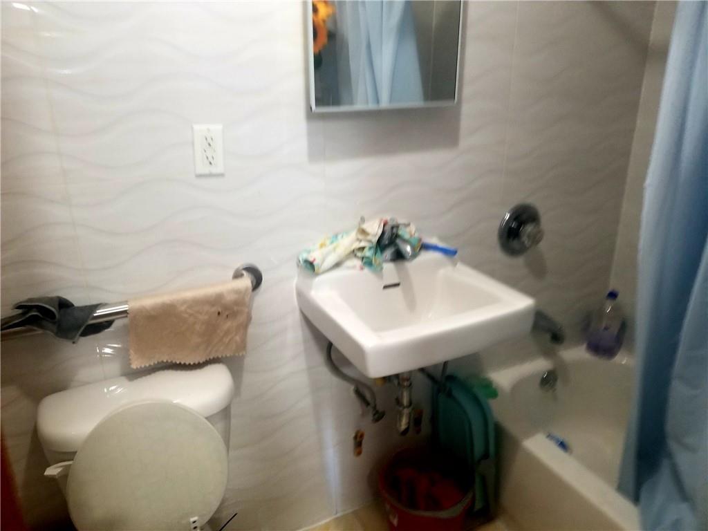 269 55th Street Brooklyn, NY 11220 - Photo 13 of 27 a bathroom with a sink and a bathtub