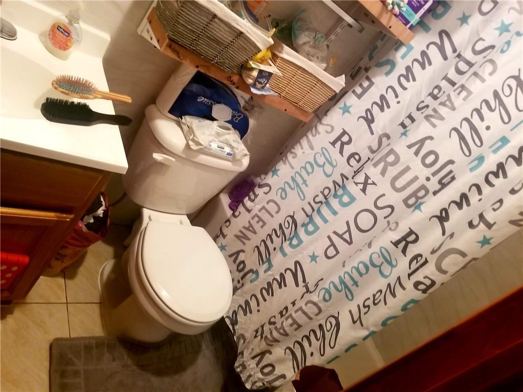 269 55th Street Brooklyn, NY 11220 - Photo 10 of 27 a bathroom with a toilet and a mirror