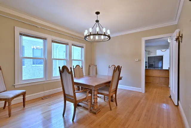 a view of a dining room with furniture a chandelier and wooden floor