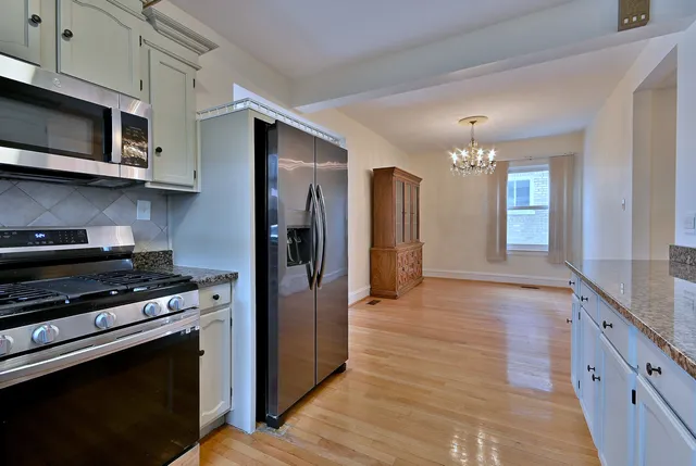a kitchen with stainless steel appliances granite countertop a refrigerator and a stove top oven