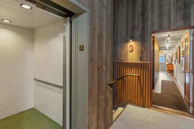 a view of a hallway with a door and stairs