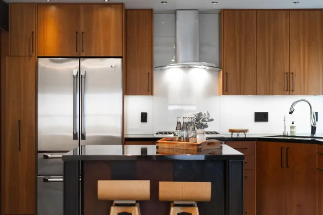 a kitchen with stainless steel appliances granite countertop a sink refrigerator and cabinets