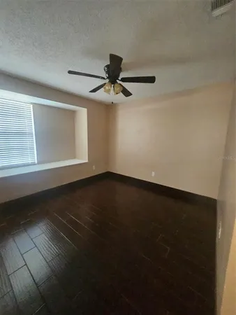 a view of a livingroom with wooden floor and a ceiling fan