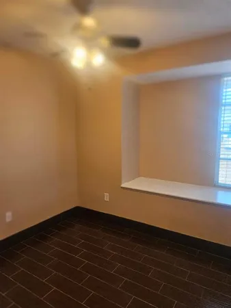 an empty room with wooden floor and a window