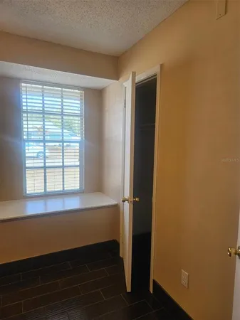 an empty room with a window and a ceiling fan