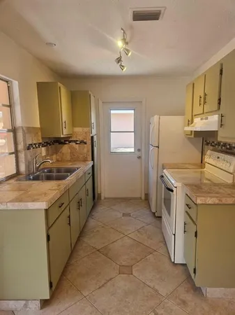 a kitchen with a sink stove and refrigerator