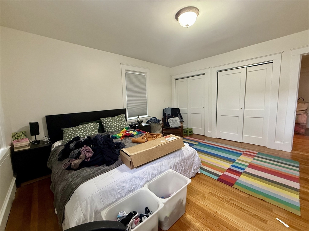 253 Brown Street, Unit 1 Waltham, MA 02453 - Photo 11 of 17 a bedroom with a bed and wooden floor