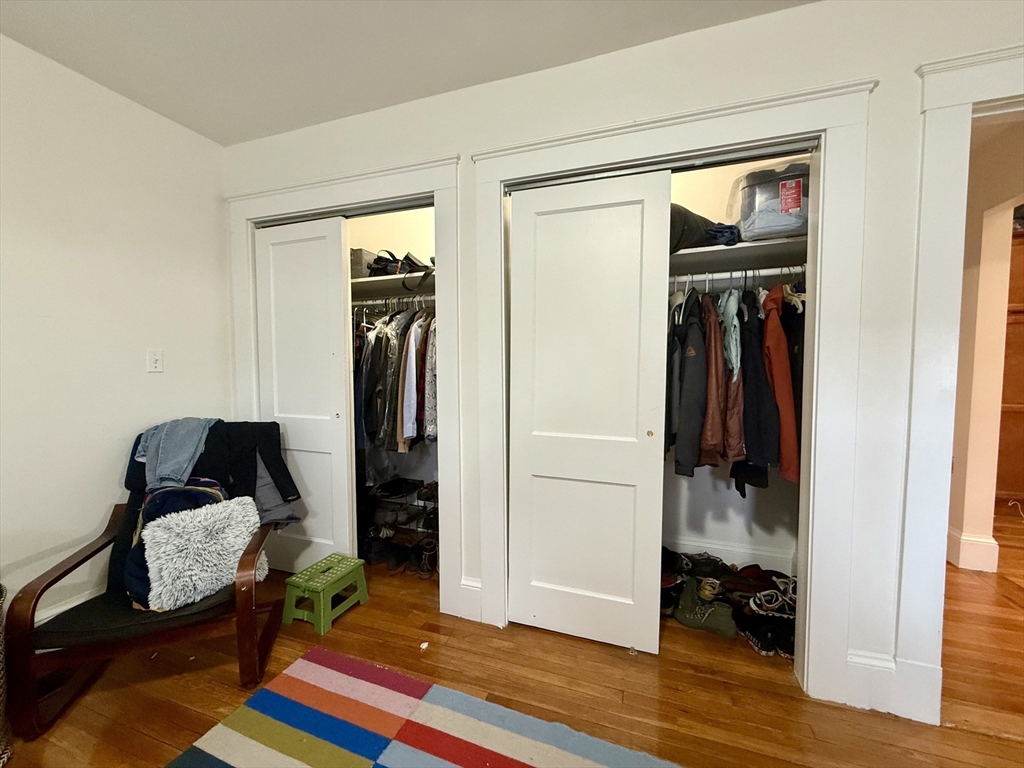 253 Brown Street, Unit 1 Waltham, MA 02453 - Photo 12 of 17 a bedroom with a bed and wooden floor