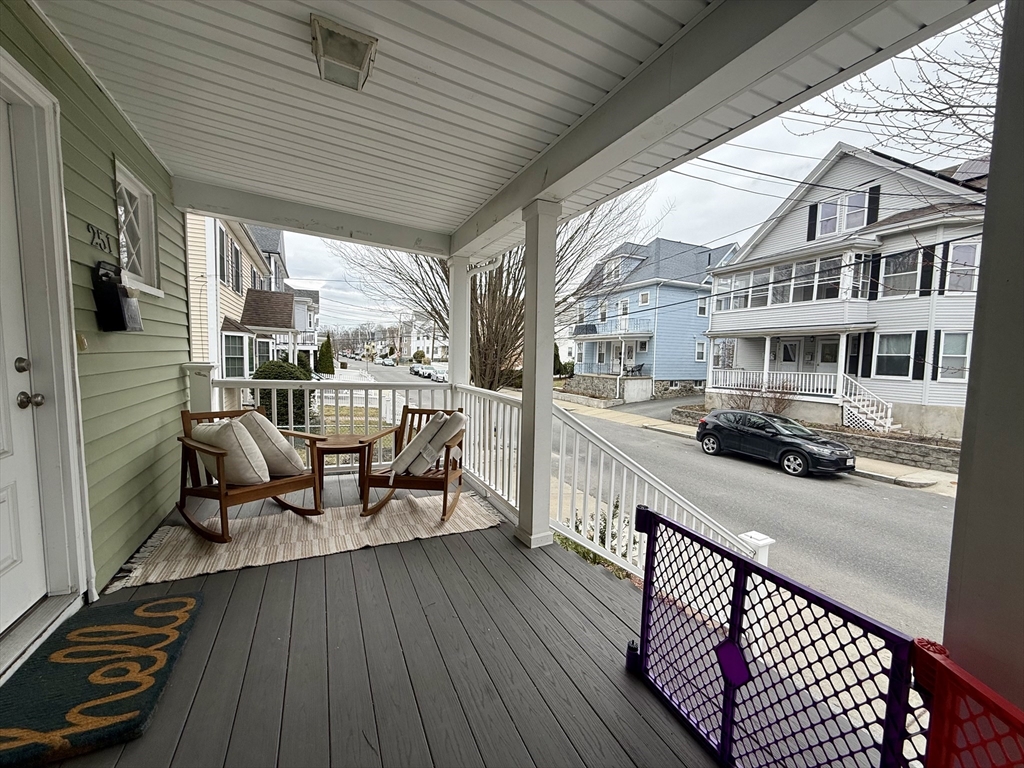 253 Brown Street, Unit 1 Waltham, MA 02453 - Photo 16 of 17 a view of a balcony with chairs and wooden floor