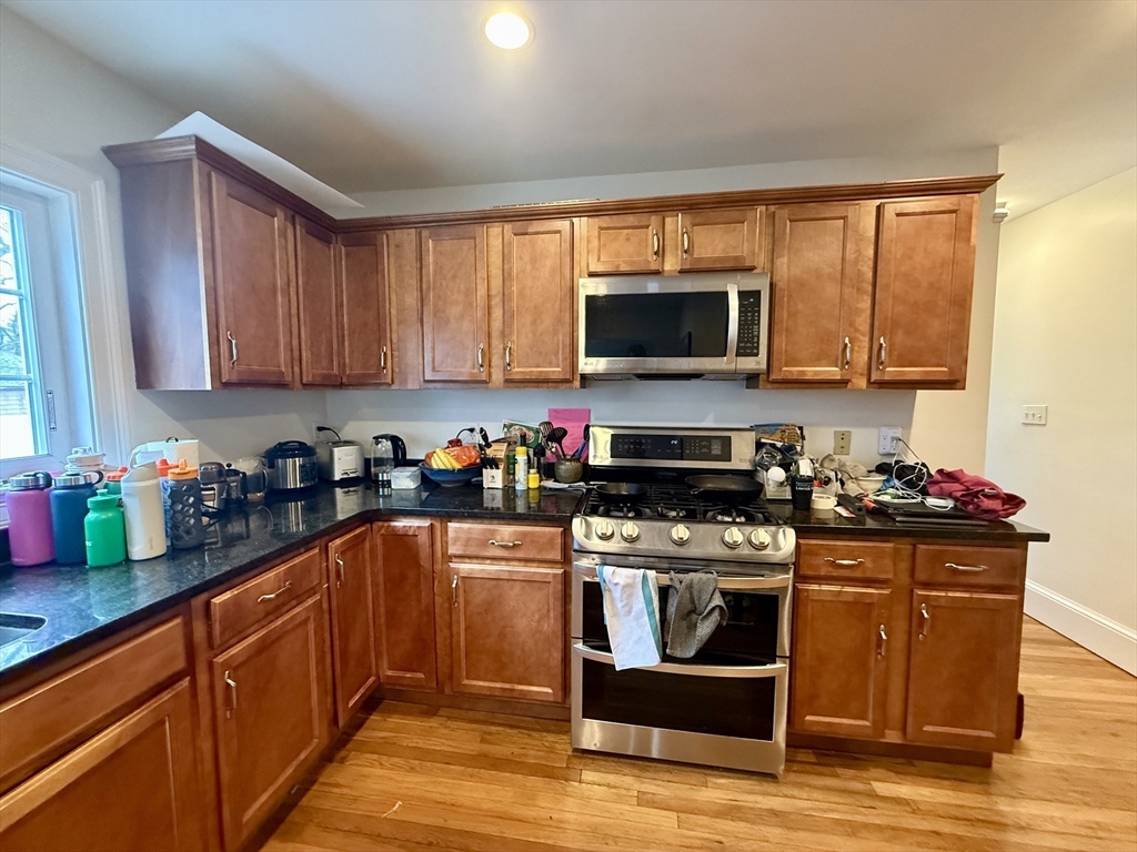 253 Brown Street, Unit 1 Waltham, MA 02453 - Photo 3 of 17 a kitchen with a sink stove top oven and microwave