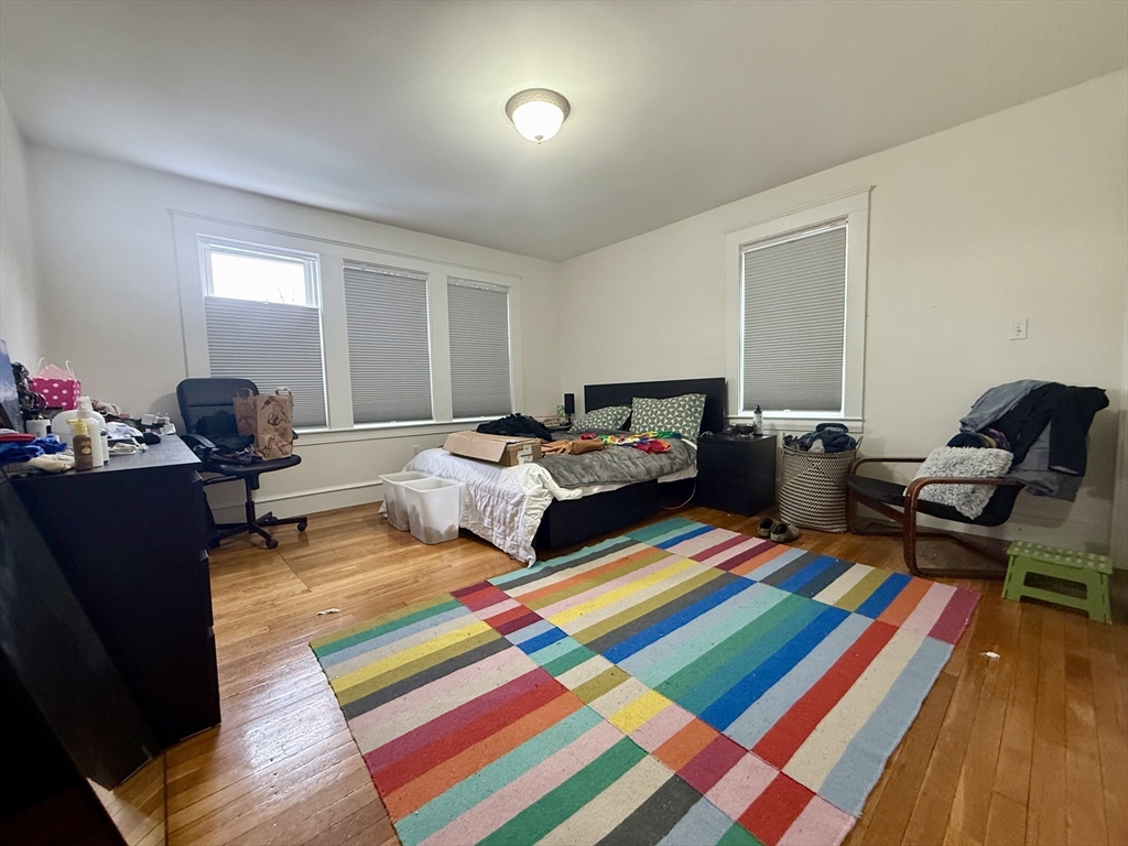 253 Brown Street, Unit 1 Waltham, MA 02453 - Photo 10 of 17 a bedroom with furniture and a wooden floor