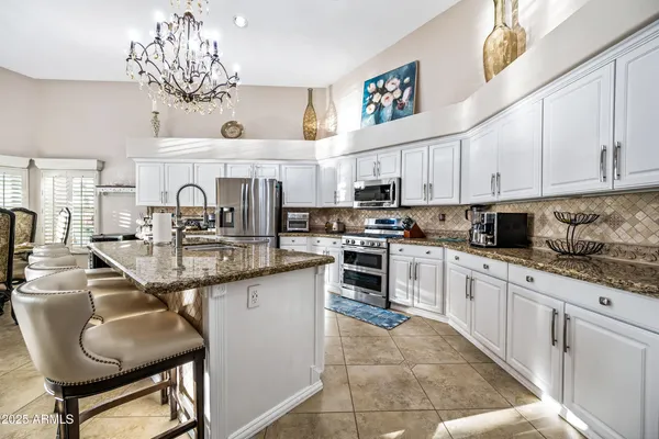 a dining room with furniture a chandelier and wooden floor