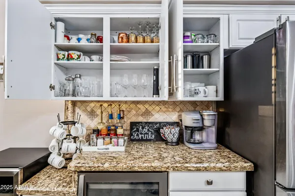 a view of pool with lawn chairs under an umbrella