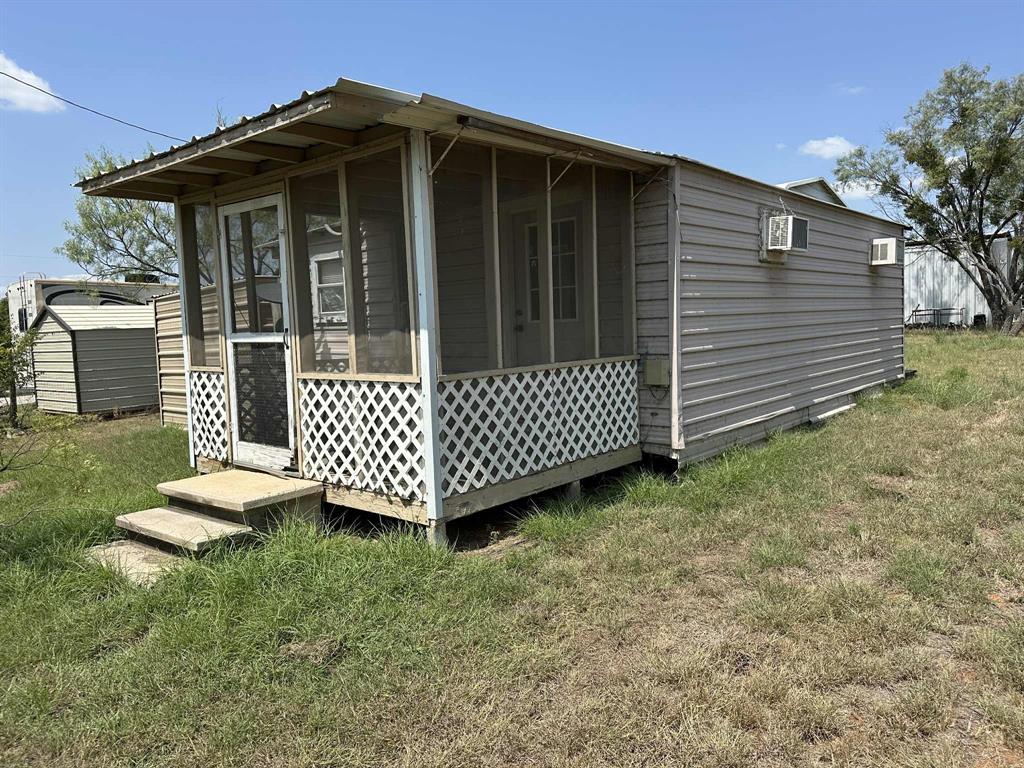 366 St Kitts Road Comanche, TX 76442 - Photo 5 of 20 a view of a wooden house with a small yard and wooden fence