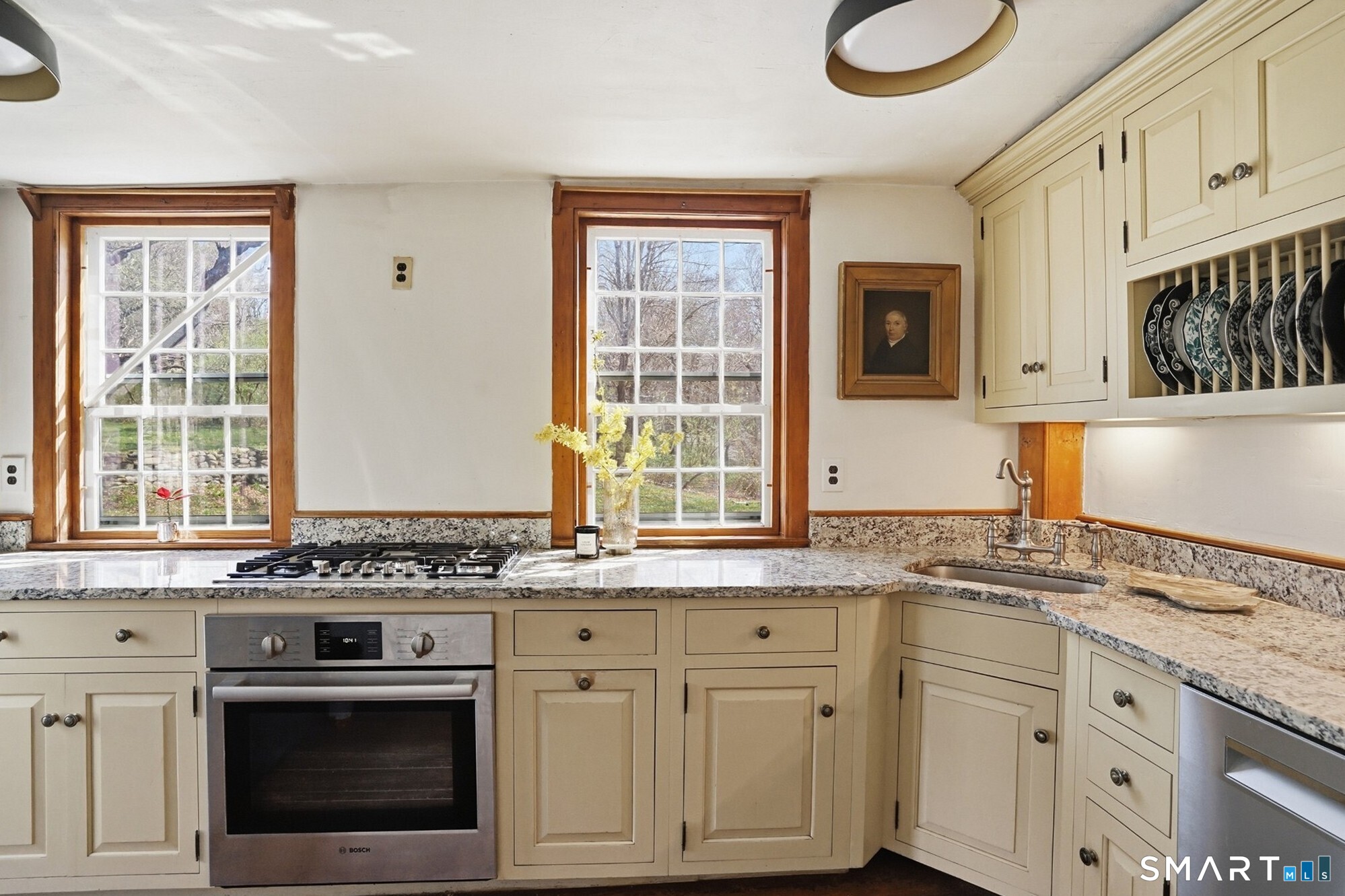 604 Pendleton Hill Road North Stonington, CT 06359 - Photo 14 of 39 a kitchen with granite countertop a stove a sink dishwasher and white cabinets with wooden floor