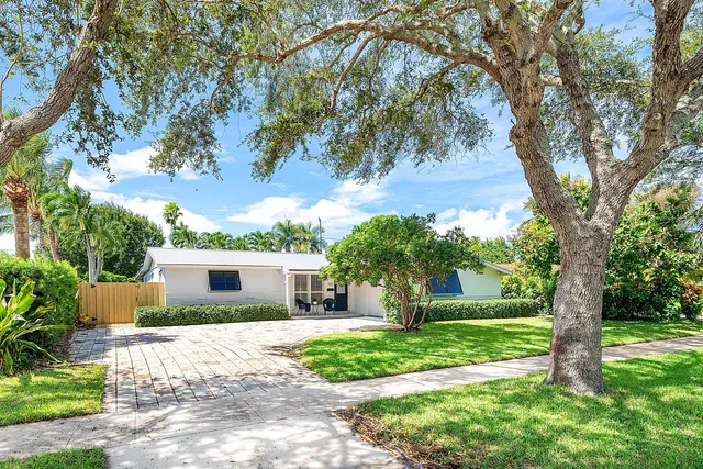 a front view of a house with a yard and an trees