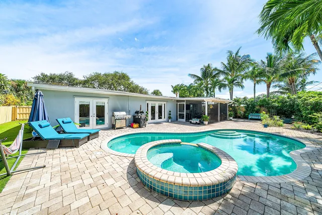 a living room with furniture a flat screen tv and a floor to ceiling window