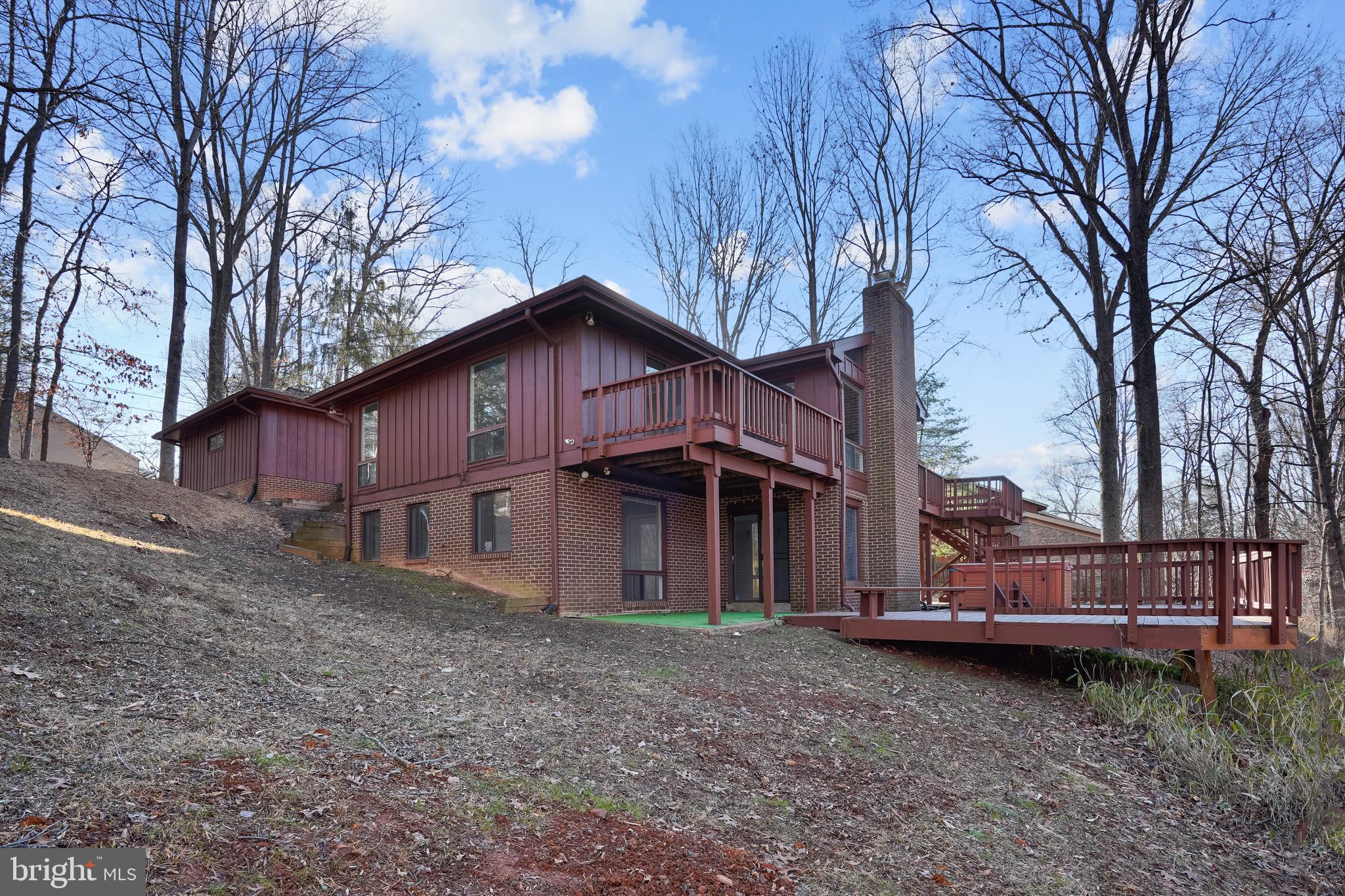 a wooden house with large trees and outdoor space