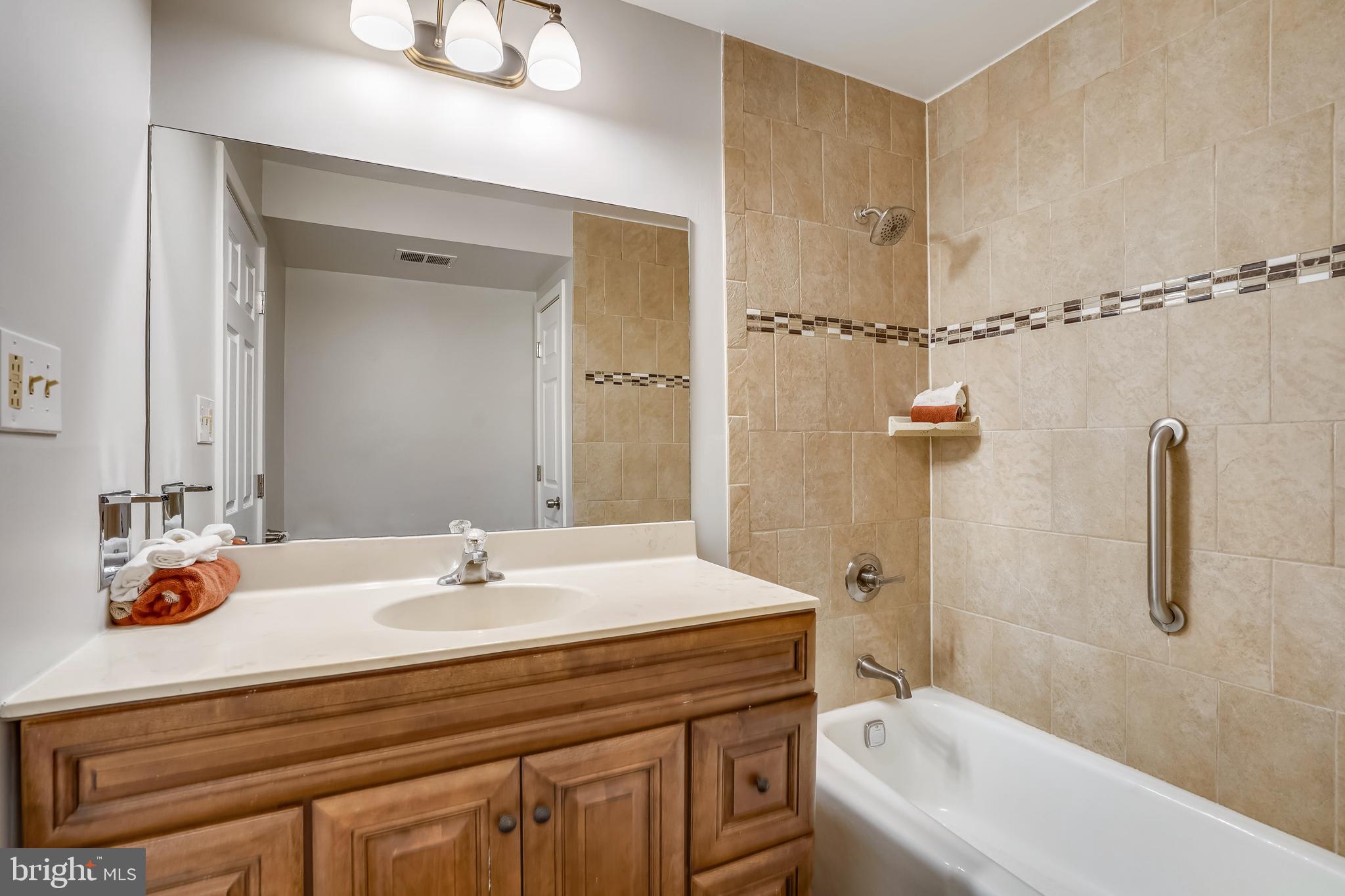 1052 Bellview Road McLean, VA 22102 - Photo 23 of 36 a bathroom with a sink a tub and a mirror