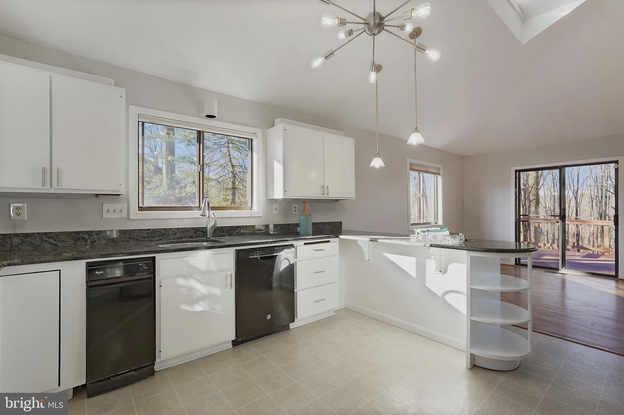 1052 Bellview Road McLean, VA 22102 - Photo 6 of 36 a large white kitchen with granite countertop a stove top oven a sink a dining table and chairs