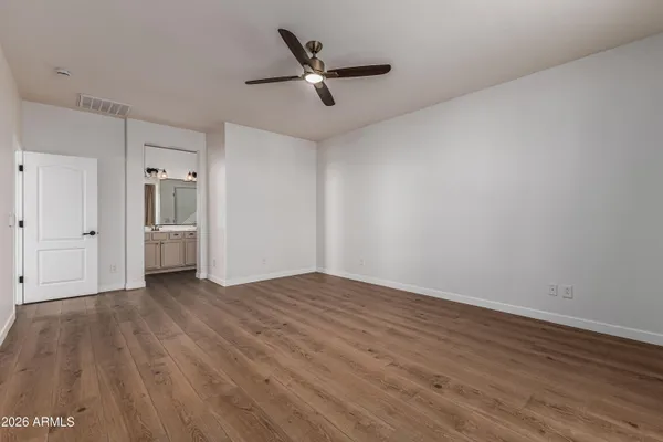a view of a livingroom with wooden floor and a ceiling fan