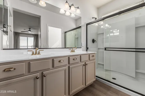 a bathroom with a double vanity sink mirror and shower