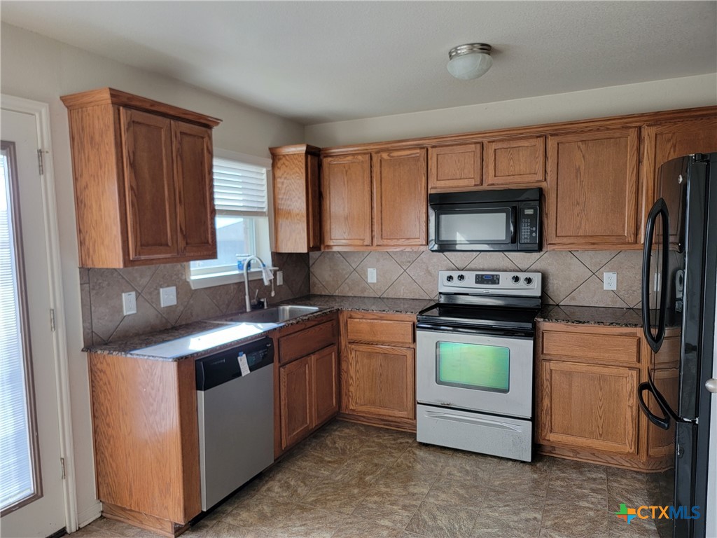 3505 Logsdon Street Copperas Cove, TX 76522 - Photo 3 of 17 a kitchen with stainless steel appliances granite countertop a stove a sink and a microwave