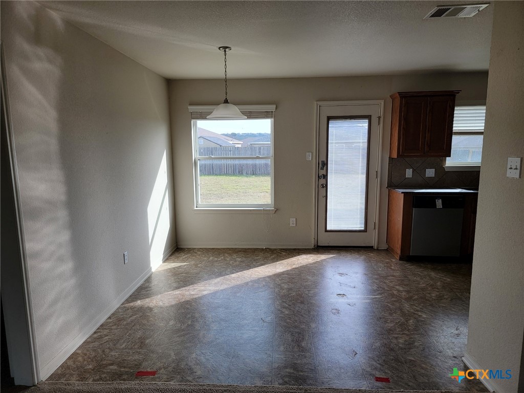 3505 Logsdon Street Copperas Cove, TX 76522 - Photo 6 of 17 an empty room with wooden floor cabinet and windows