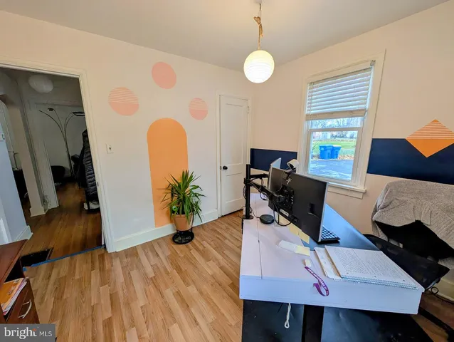 a view of a workspace with furniture and a wooden floor