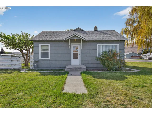 a front view of a house with yard and green space