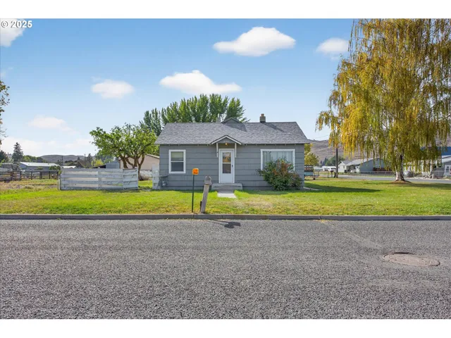 a view of a house with a big yard and palm trees