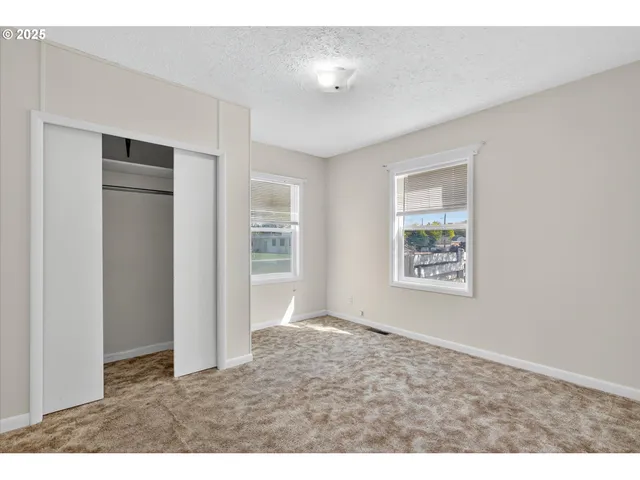 an empty room with windows and closet