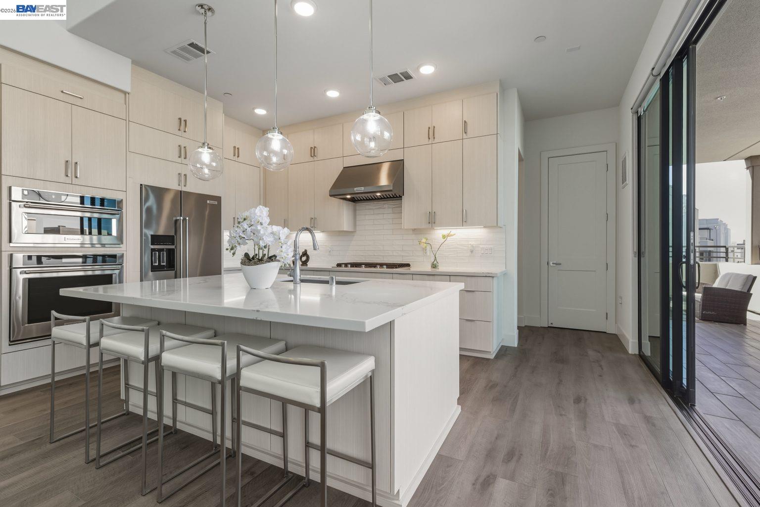 1748 Kilowatt Way, Unit 402 Fremont, CA 94539 - Photo 18 of 60 a kitchen with kitchen island a stove a table and chairs in it