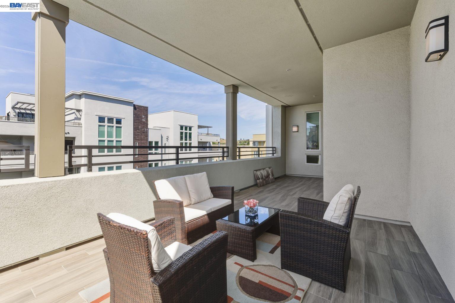 1748 Kilowatt Way, Unit 402 Fremont, CA 94539 - Photo 23 of 60 a living room with couches and kitchen view with wooden floor