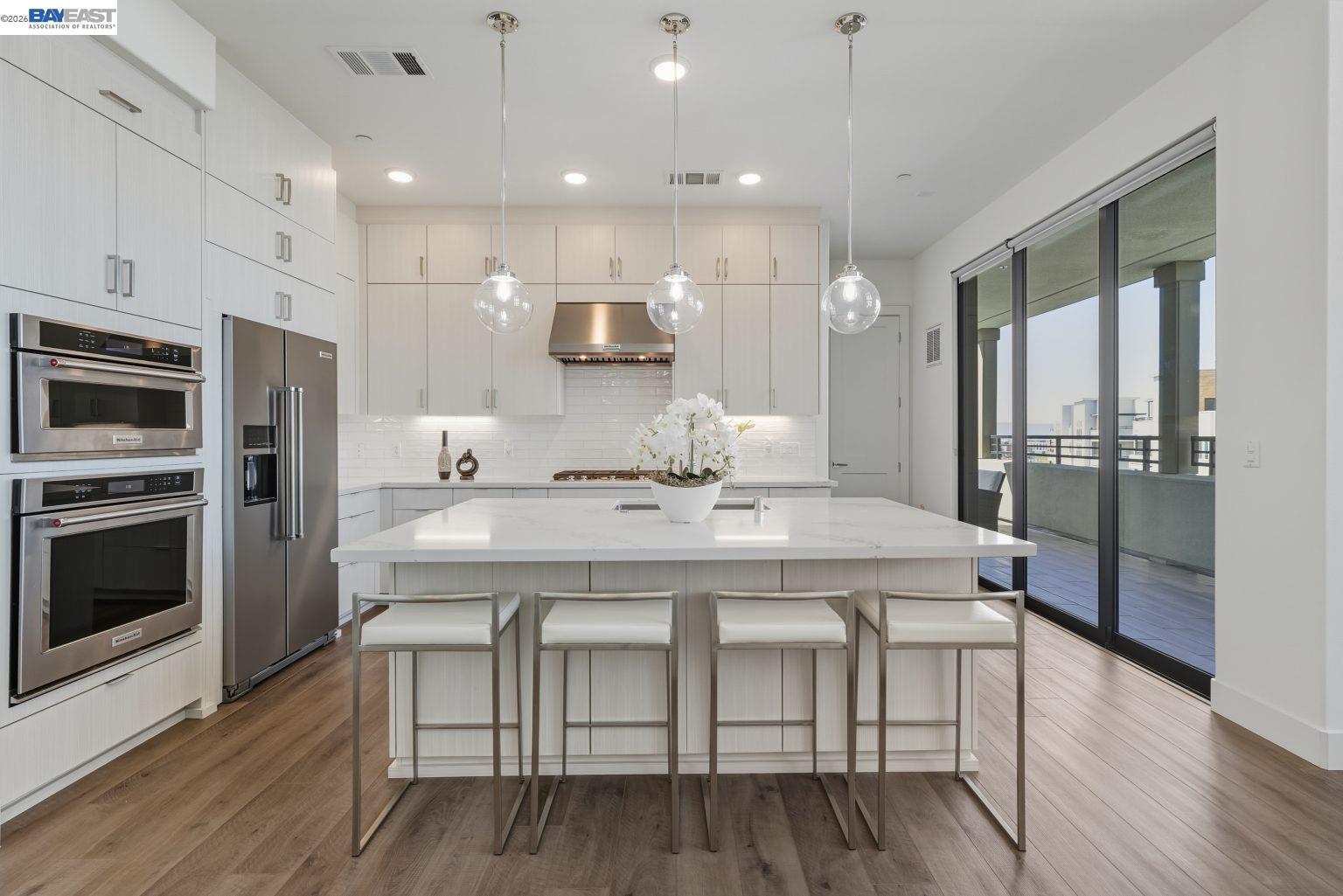 1748 Kilowatt Way, Unit 402 Fremont, CA 94539 - Photo 5 of 60 a kitchen with stainless steel appliances a dining table chairs stove refrigerator and microwave