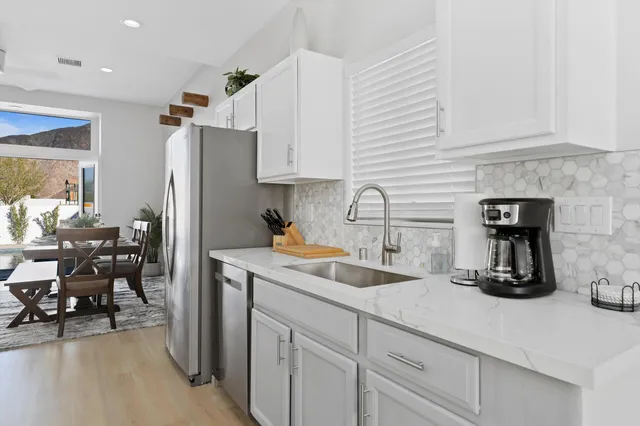 a kitchen with a sink a refrigerator and cabinets
