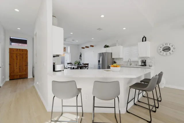 a kitchen with stainless steel appliances kitchen island granite countertop a sink and chairs