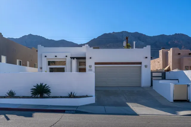 a front view of a house with a yard and mountain view