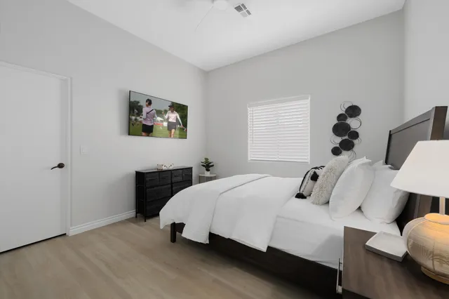 a bedroom with a bed and a painting on the wall