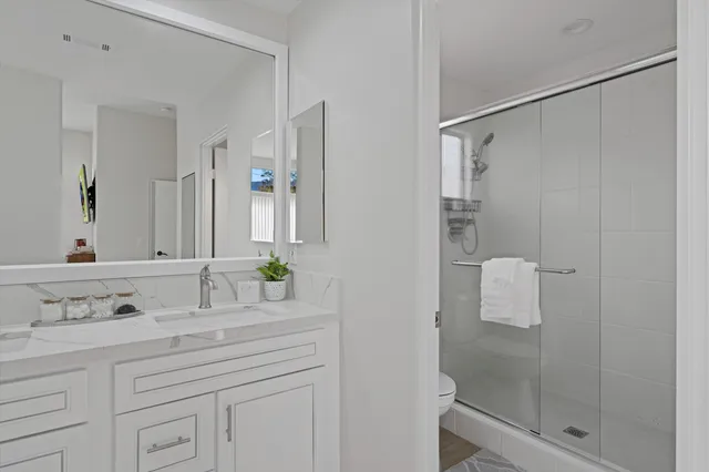 a bathroom with a shower sink and mirror