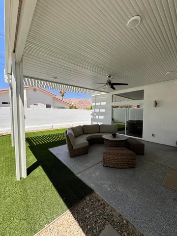 a living room with patio furniture and a rug