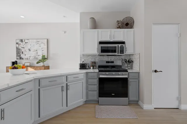 a kitchen with cabinets stainless steel appliances and a counter space