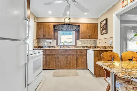 a kitchen with stainless steel appliances granite countertop a sink a stove and a refrigerator
